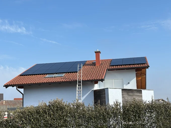 Photovoltaikmodule auf Hausdach mit Leiter